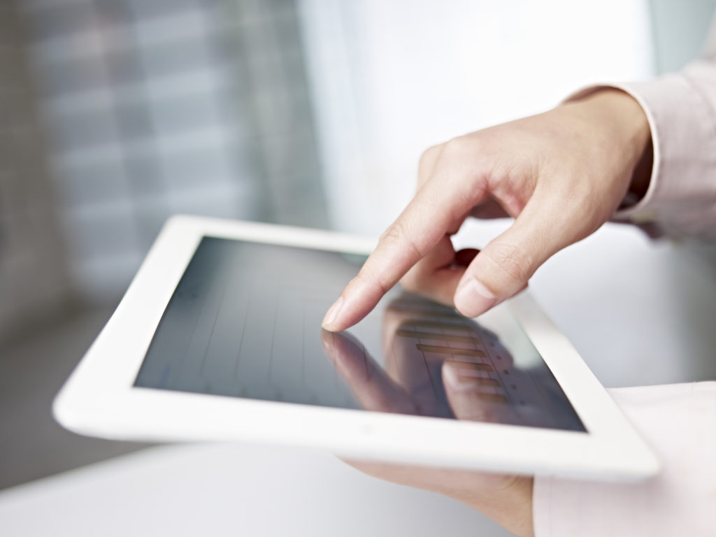 tablet computer with a female hand using it.