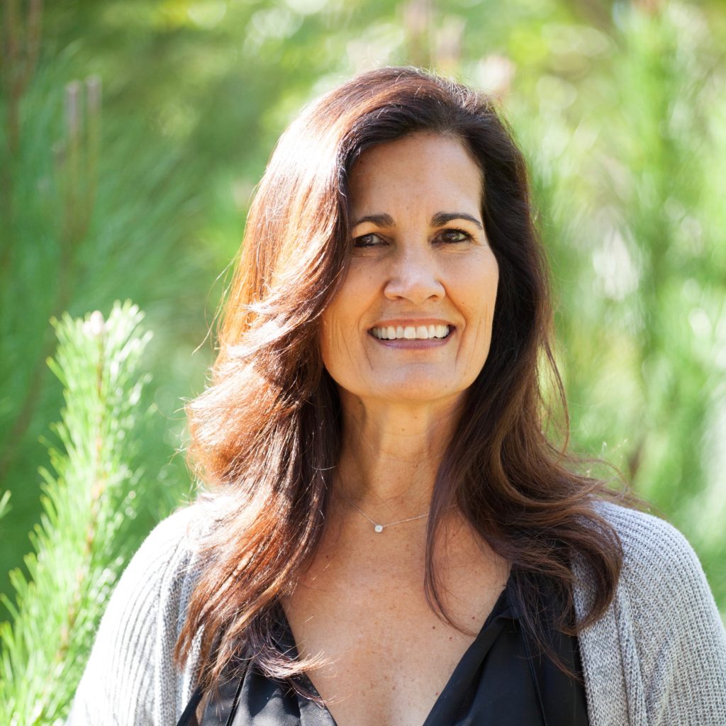 Linda Fuchser, she has long wavy brown hair and is smiling