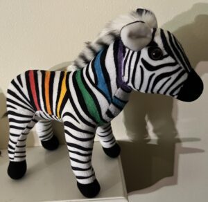 Stuffed toy zebra with colorful stripes.